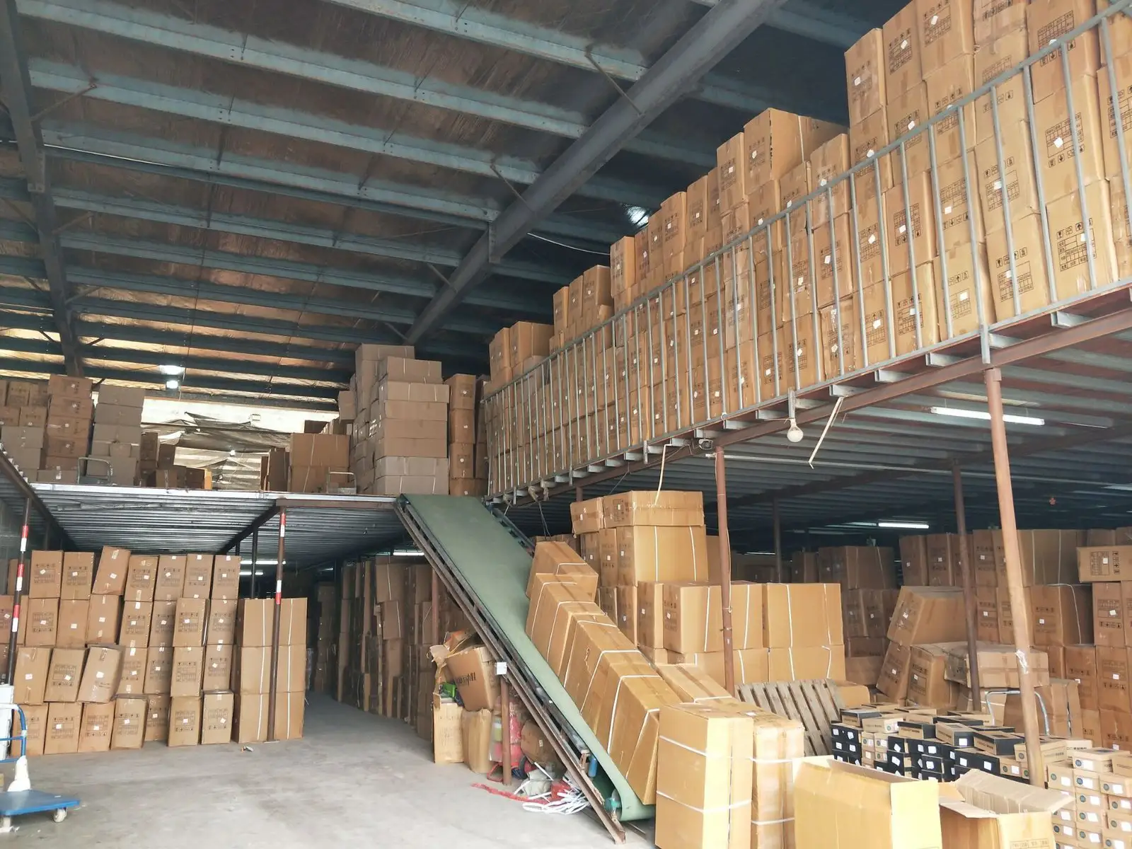成品仓库实拍：货物按批次码放在货架上、离地离墙存放待发