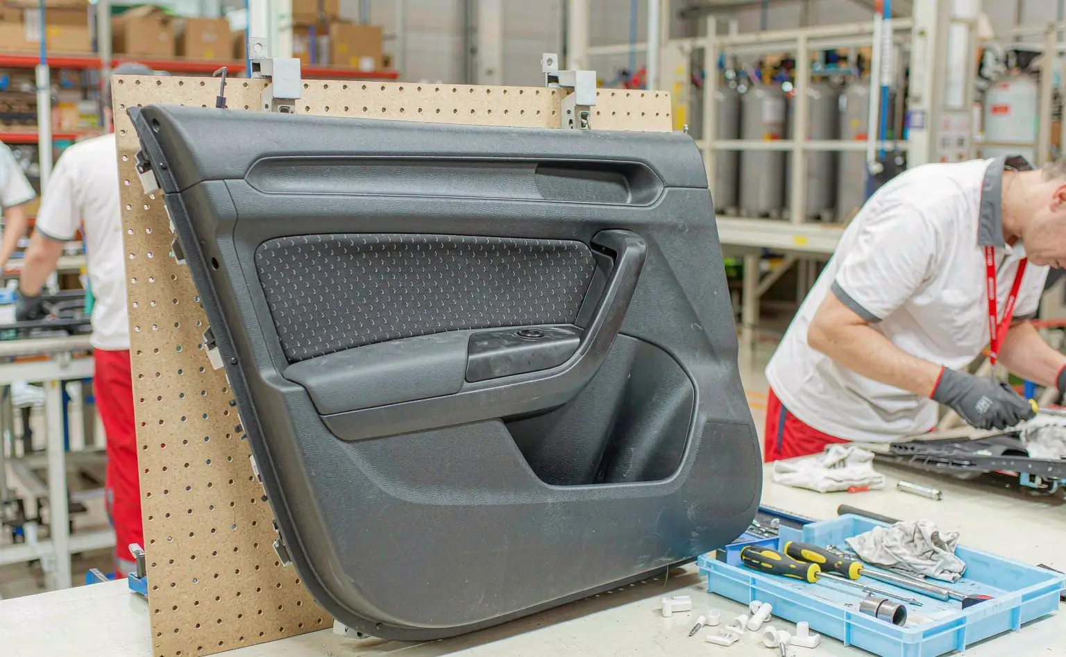 Automotive interior assembly station: door panels and trims fitted on a jig, waiting for the assembly test