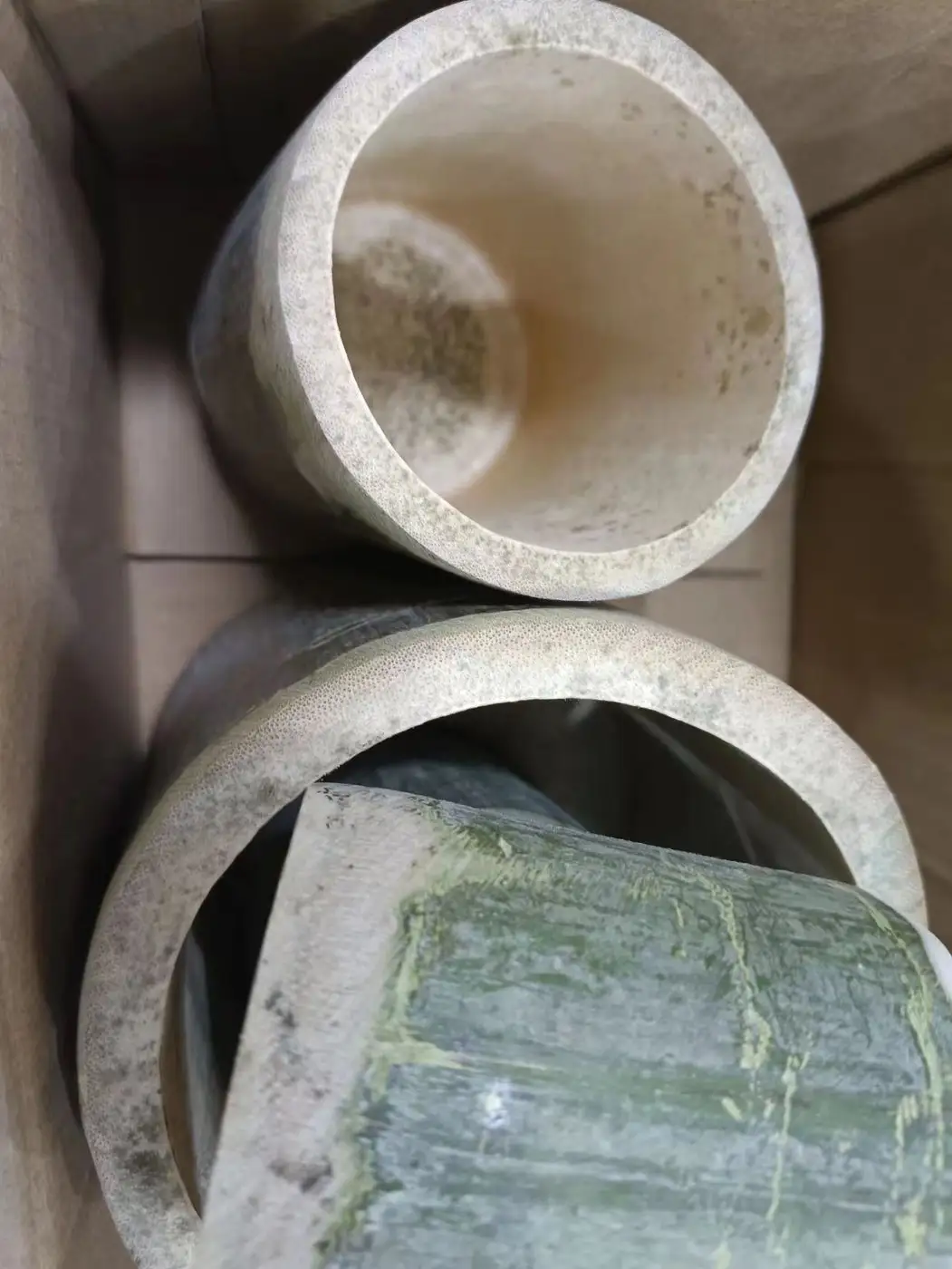 纸箱里并排的几只藤编罐,内壁与口沿能看到成片霉斑,箱内衬着牛皮纸